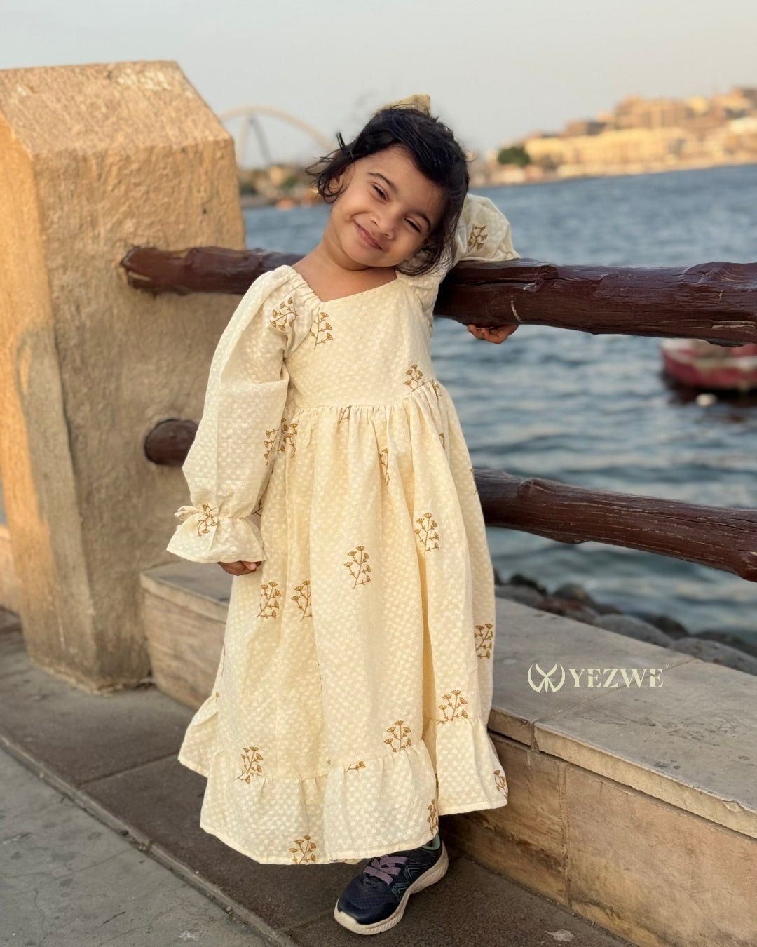 Buttercream floral full-length kids modest dress with long sleeves and soft flared fit.