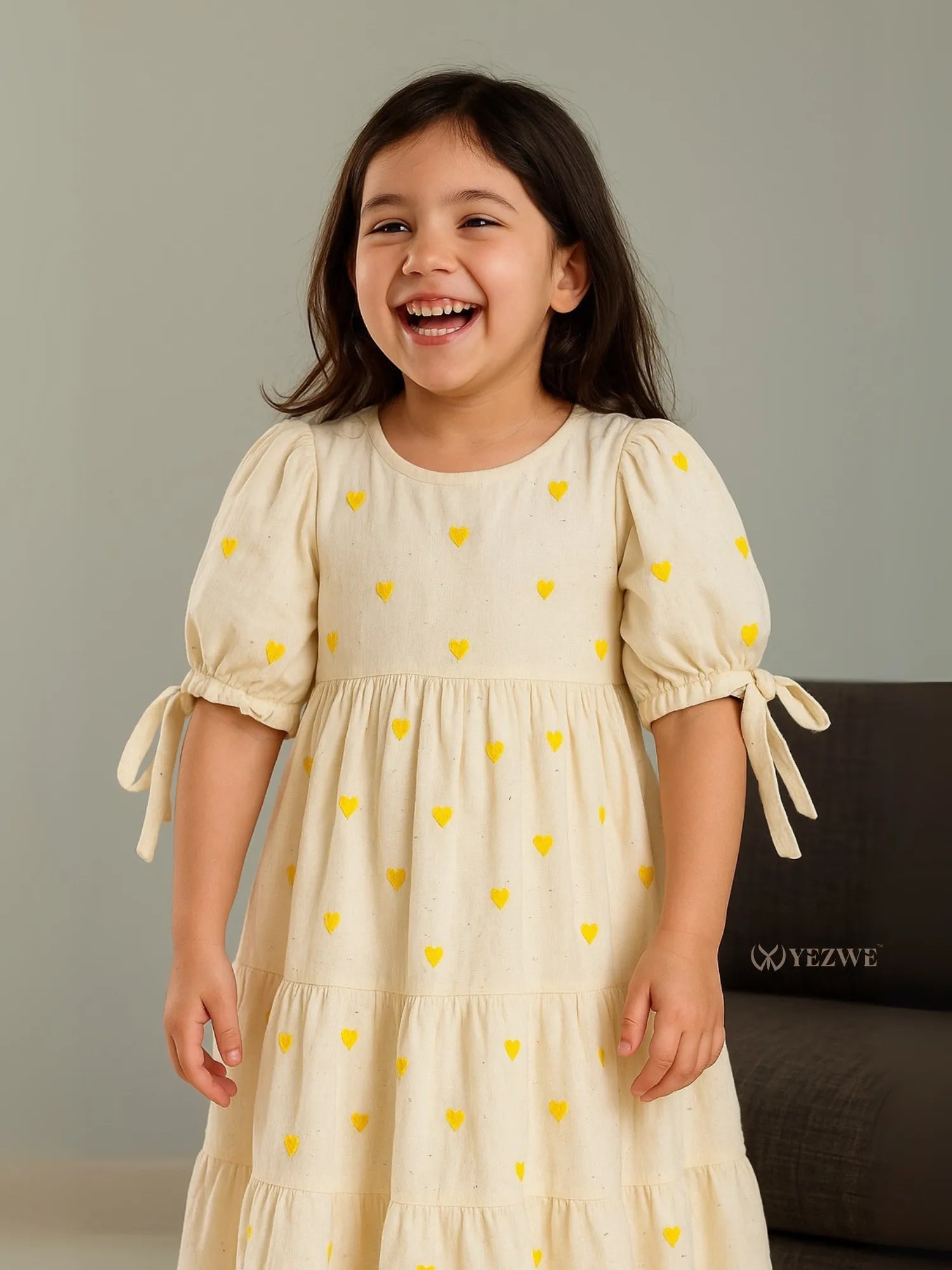 A girl in Yezwe Miniature Yellow Love Embroidered Kora Modest Maxi Dress For Junior Girls laughing