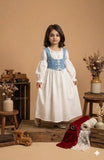 Junior girl wearing white long sleeve maxi dress with blue corset style bodice in studio setup