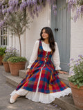 YEZWE Hakoba Dress with Madras Checks Layered Overdress Shrug styled on a model outdoors with floral decor
