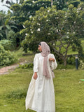 Yezwe modest off white maxi dress with long sleeves and flowing design in a garden setting