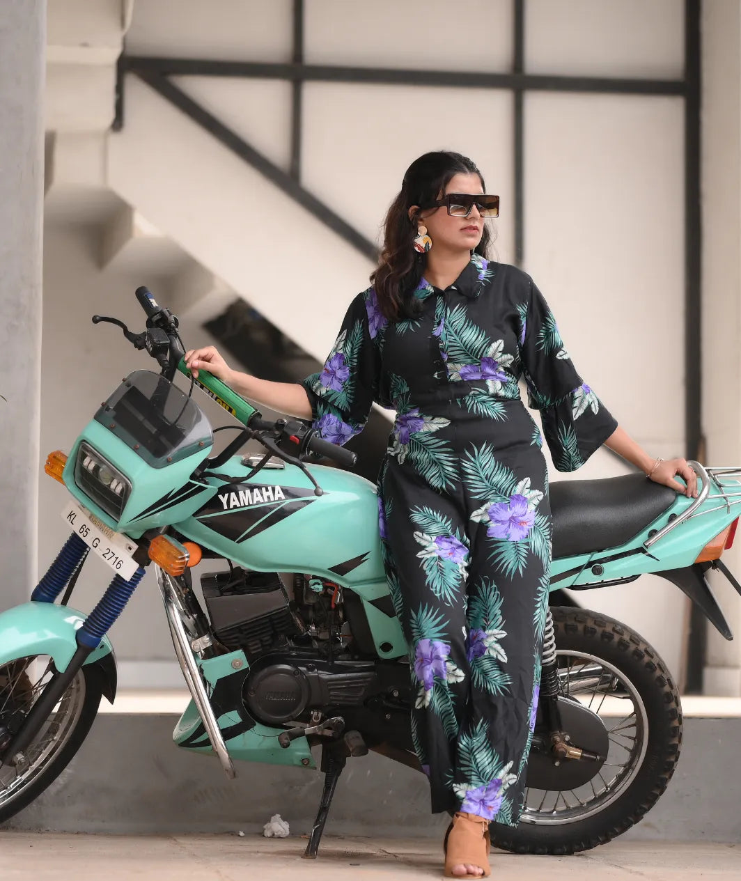 Yezwe modest wear jumpsuit in floral print worn by a woman posing with a motorcycle