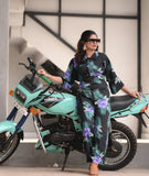 Yezwe modest wear jumpsuit in floral print worn by a woman posing with a motorcycle
