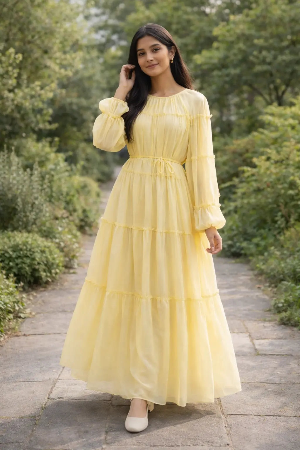 Woman wearing a pastel yellow tiered maxi dress with long sleeves and flowy silhouette, modest Pinterest style outfit for casual wear