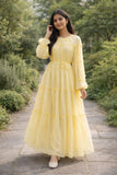 Woman wearing a pastel yellow tiered maxi dress with long sleeves and flowy silhouette, modest Pinterest style outfit for casual wear
