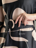 Close-up of black abstract print modest maxi dress featuring a stylish belt by YEZWE