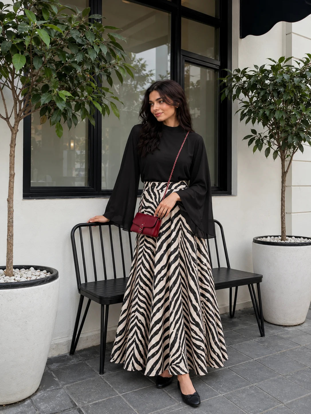 YEZWE Black Mock Neck Bell Sleeve Top & Zebra Print High Waist Flared Maxi Skirt styled outdoors with a chic handbag