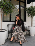 YEZWE Black Mock Neck Bell Sleeve Top & Zebra Print High Waist Flared Maxi Skirt worn in a stylish outdoor setting