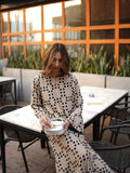 YEZWE beige co-ord set featuring a long tunic with pant in black polka dot pattern worn by woman sitting outdoors