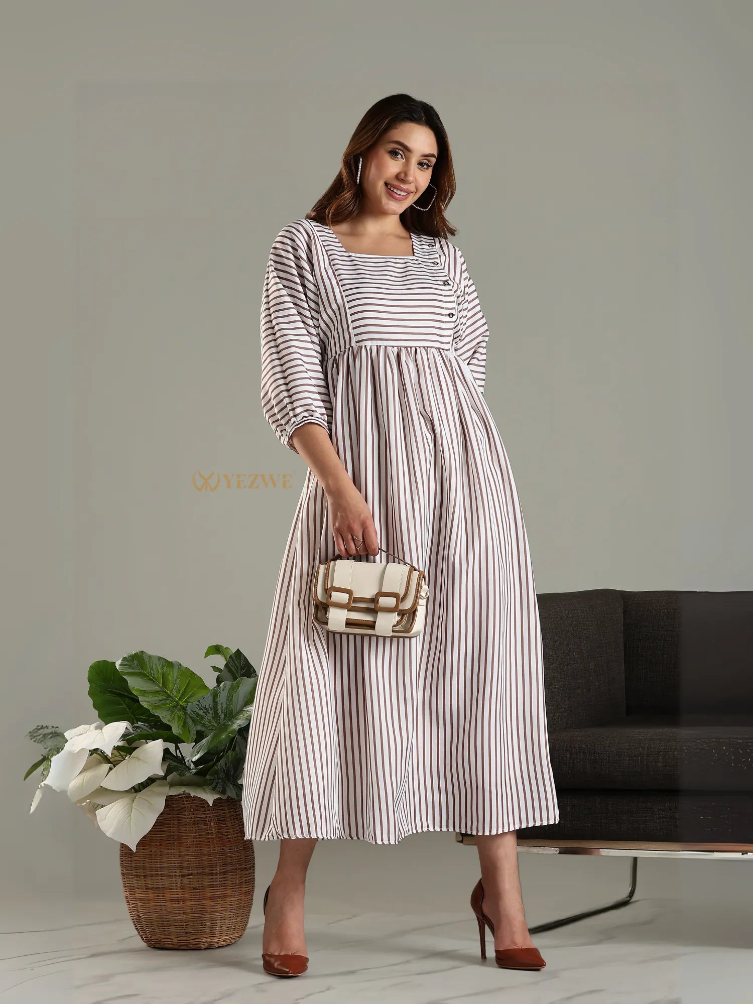 Yezwe striped maxi dress with three-quarter sleeves styled with brown heels and a beige handbag