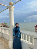 Woman wearing a modest co-ord set from YEZWE standing by seaside balcony under cloudy sky