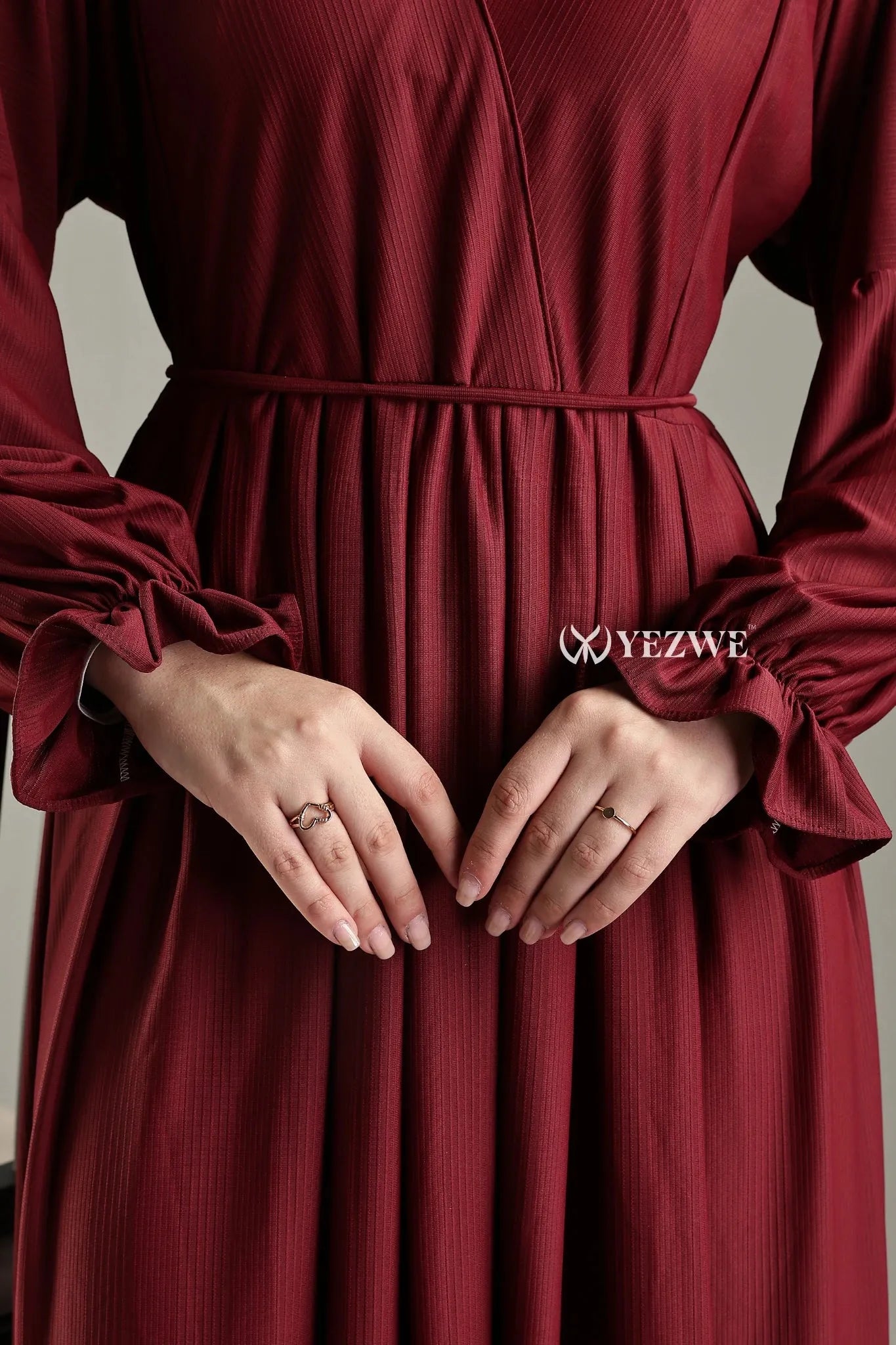 Modest long sleeve maxi maroon dress by YEZWE with elegant detailing and cinched waist
