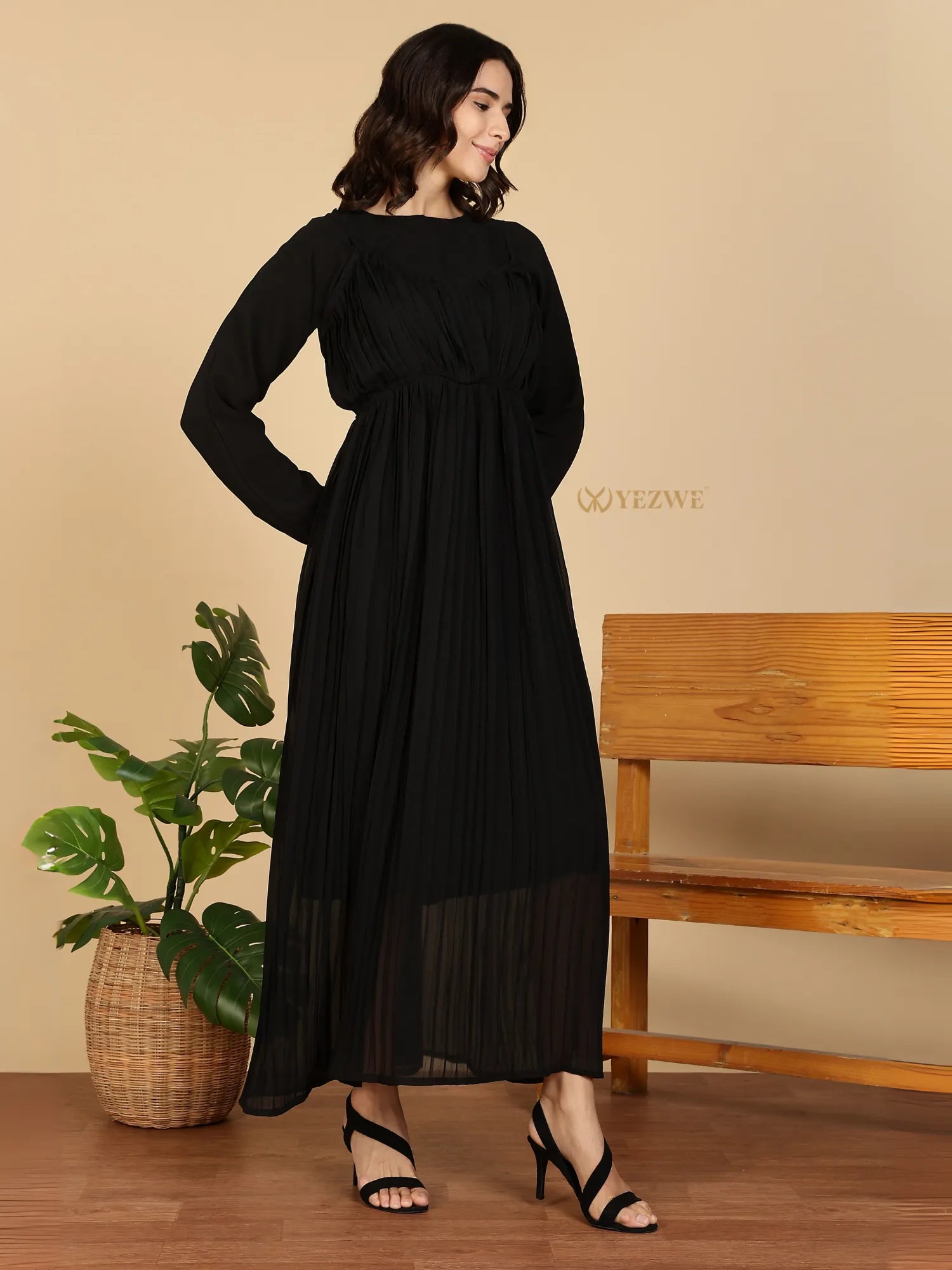 YEZWE Modest Maxi Dress black pleated long sleeve maxi dress on model with strappy heels