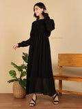 YEZWE black Modest Maxi Dress with long sleeves pleated skirt and empire waist worn by smiling model