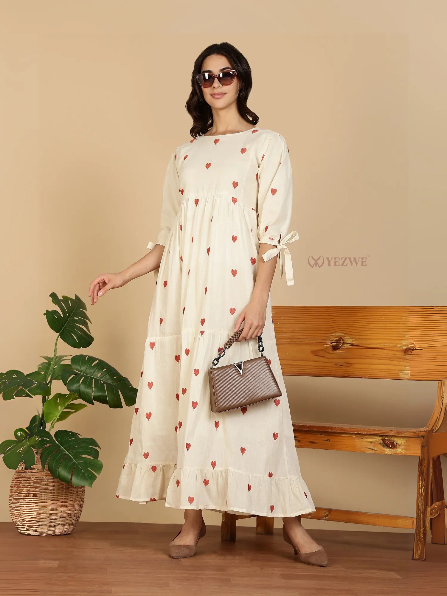 Yezwe Modest Maxi Dress cream with red heart print tie sleeves and ruffle hem model with sunglasses and brown handbag