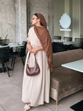 YEZWE modest Occasion wear beige flare dress styled with a brown scarf and a matching bag in a chic café setting