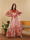 YEZWE Modest Party Wear Maxi Dress rose gold satin long sleeve with tie waist ruffle hem on model