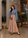 YEZWE Slate Blue Mock Neck Bell Sleeve Top & Leopard Print Flared Maxi Skirt styled in a modern indoor setting