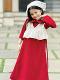 young girl wearing wine maroon modest maxi dress with a cream layered top smiling in a cute pose outdoors