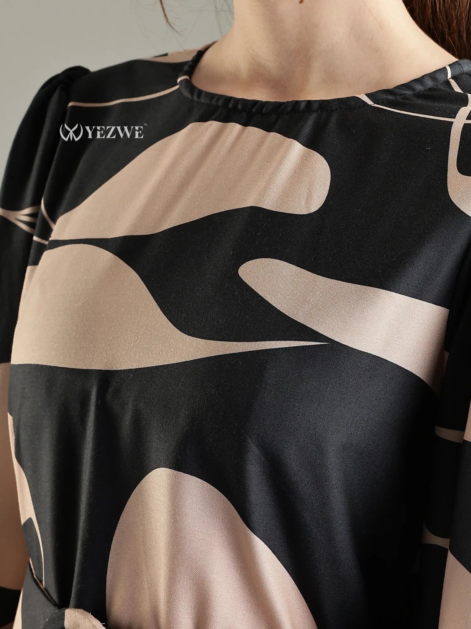 Close-up of YEZWE black abstract print modest maxi dress showcasing fabric detail and unique design