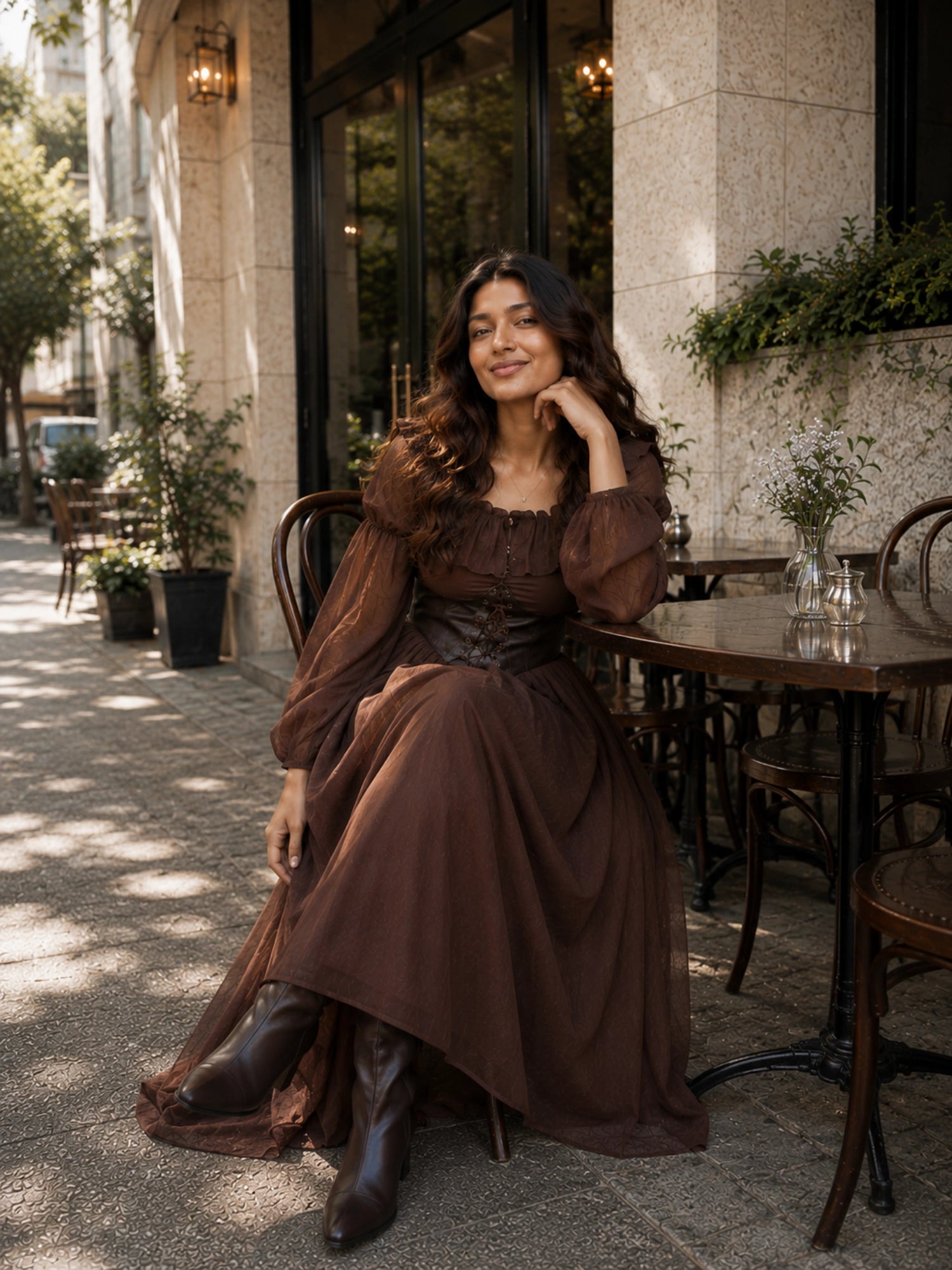 Stylish woman wearing a brown corset maxi dress while seated at an outdoor café table