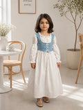 Junior girl wearing white long sleeve maxi dress with blue lace-up corset bodice indoors