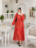 Woman wearing a coral red modest maxi dress with puff sleeves and white hijab in an elegant white café interior.