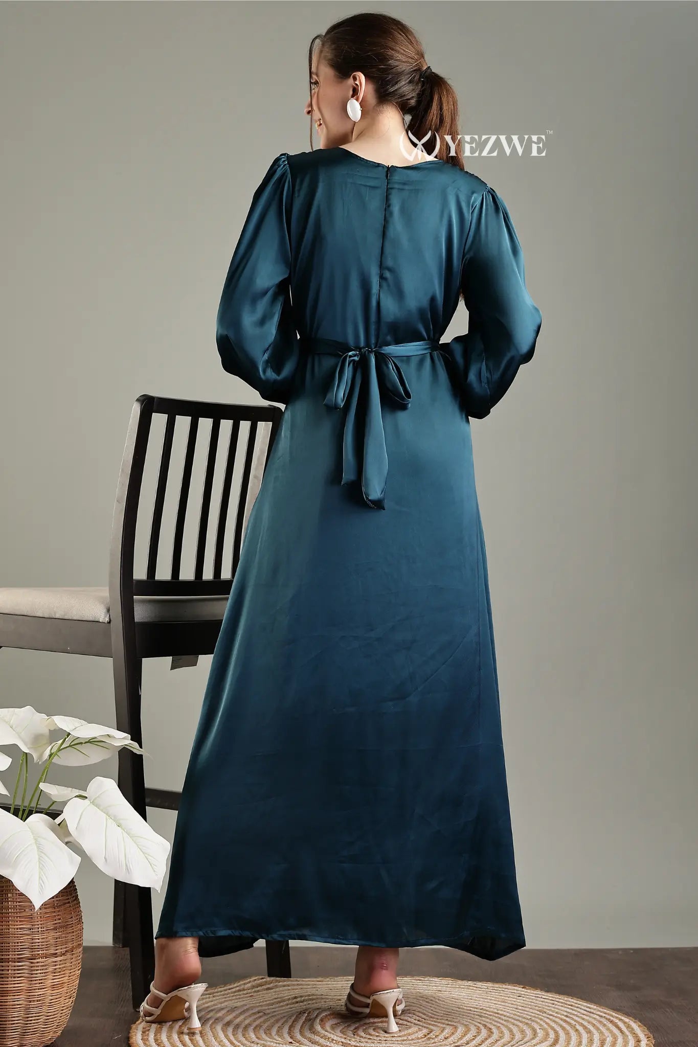 Back view of a YEZWE blue satin flare modest gown with a tied waist and stylish sleeves
