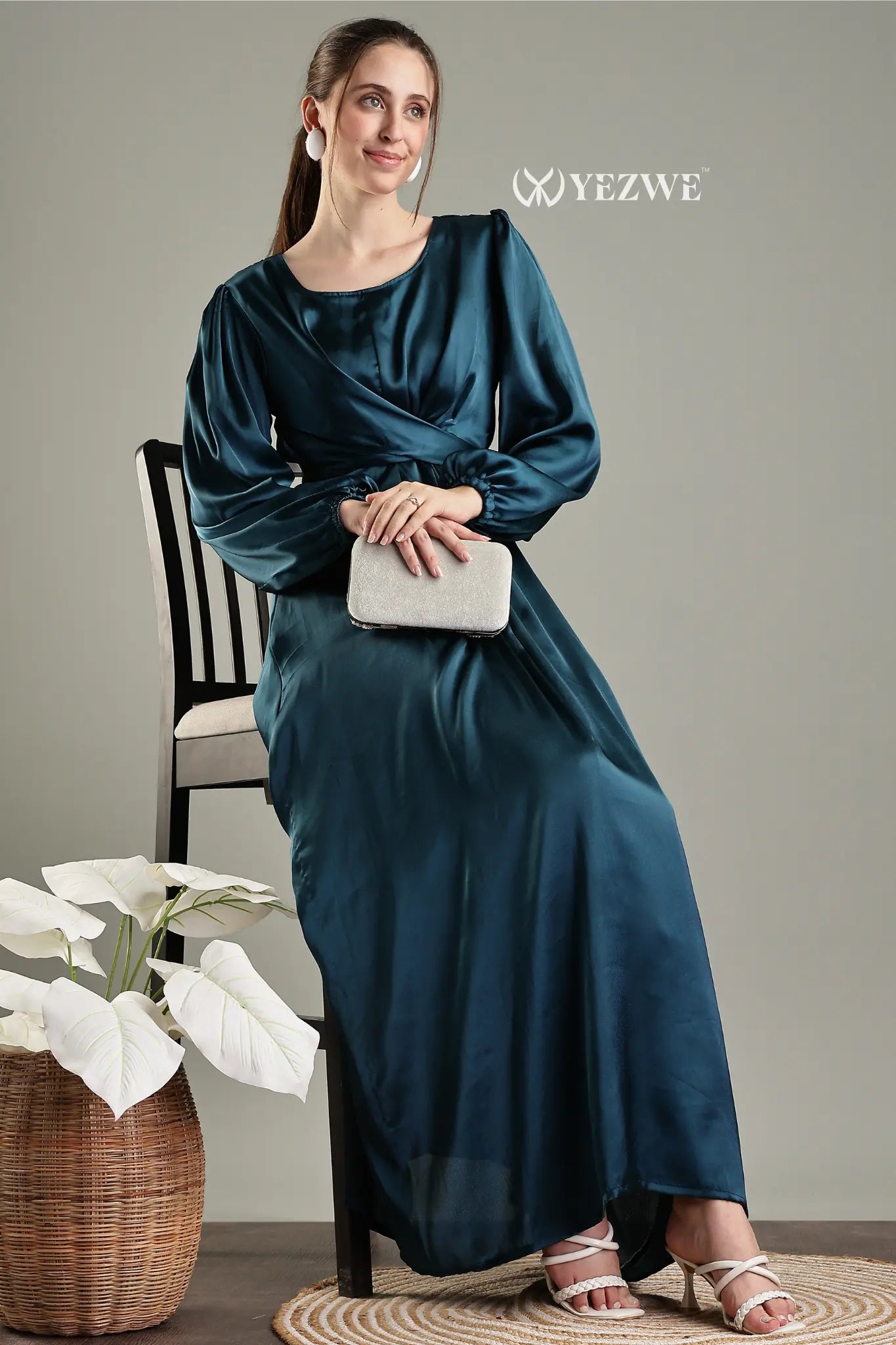 YEZWE blue satin flare modest gown with long sleeves and a sleek silhouette, styled with a clutch