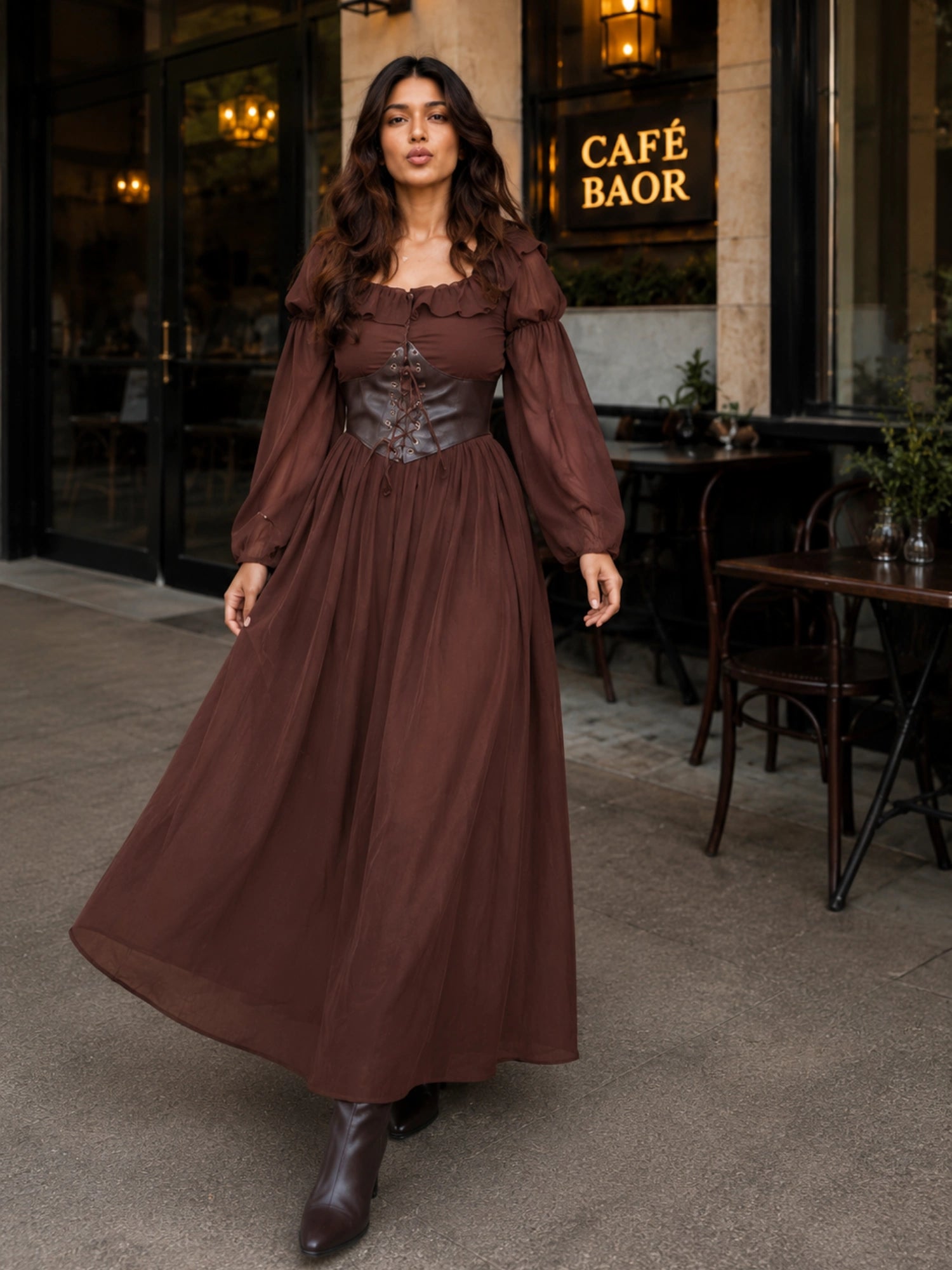 Beautiful woman in a brown corset maxi dress with long sleeves walking outside a café