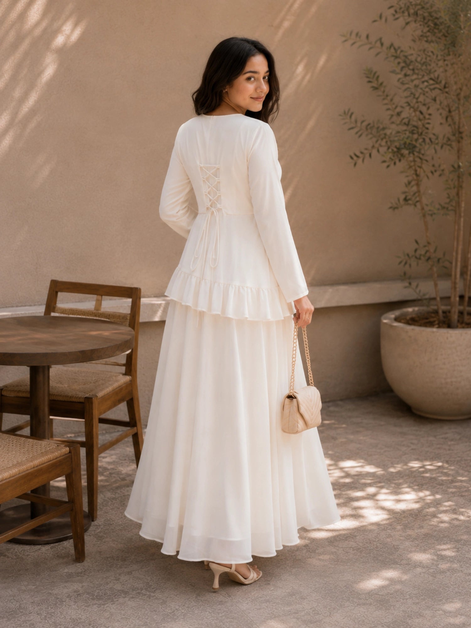 Woman in Ivory Faux Georgette Asymmetric Ruffle Maxi Dress with lace-up back detail