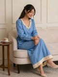 Woman sitting wearing a light blue denim co-ord set with hakoba detailing, modest elegant outfit for everyday wear