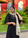 Modest black maxi dress with ruffled sleeves, paired with a beige scarf for an elegant look