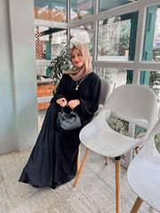 Elegant modest black maxi dress by Yezwe, styled with a scarf and bag for a chic look