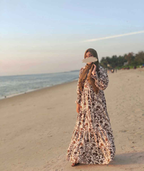 Yezwe modest mehendi green maxi dress featuring floral patterns and long sleeves on a beach