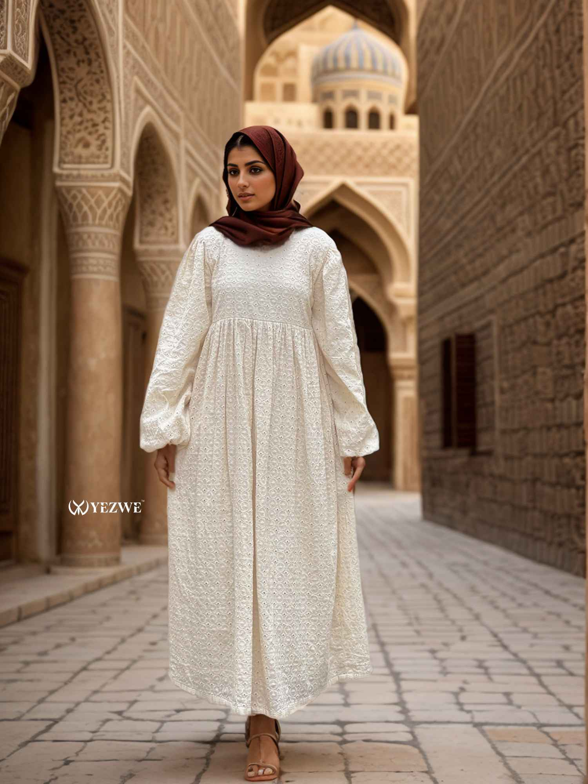 Yezwe modest off-white maxi dress with long sleeves and a flowing silhouette in a beautiful outdoor setting