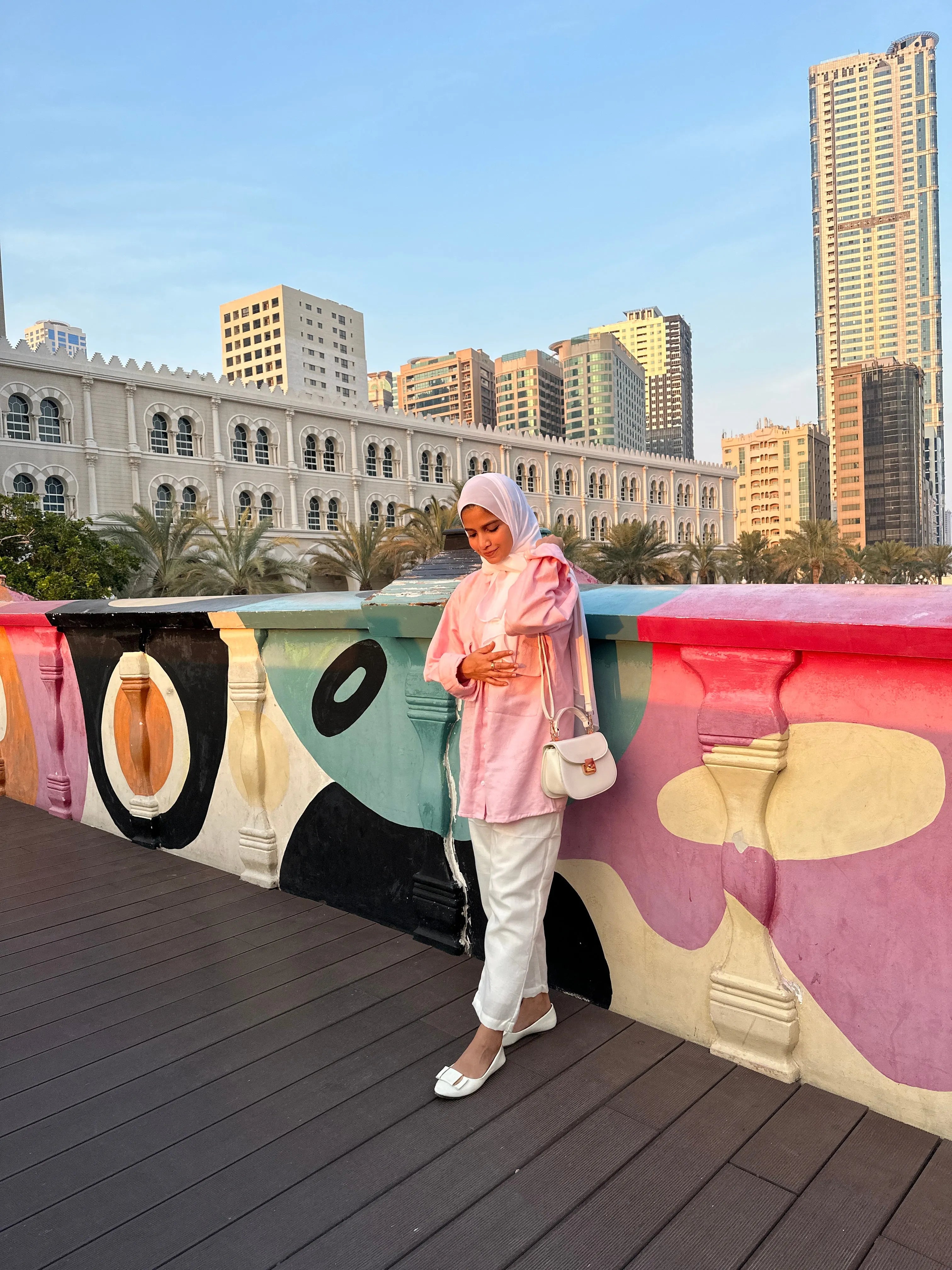 Modest oversized co-ord set featuring a pink top and white pants, styled for a chic outdoor look