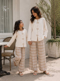Mom and daughter matching co ord set featuring a stylish top and wide-leg pants in a light color scheme