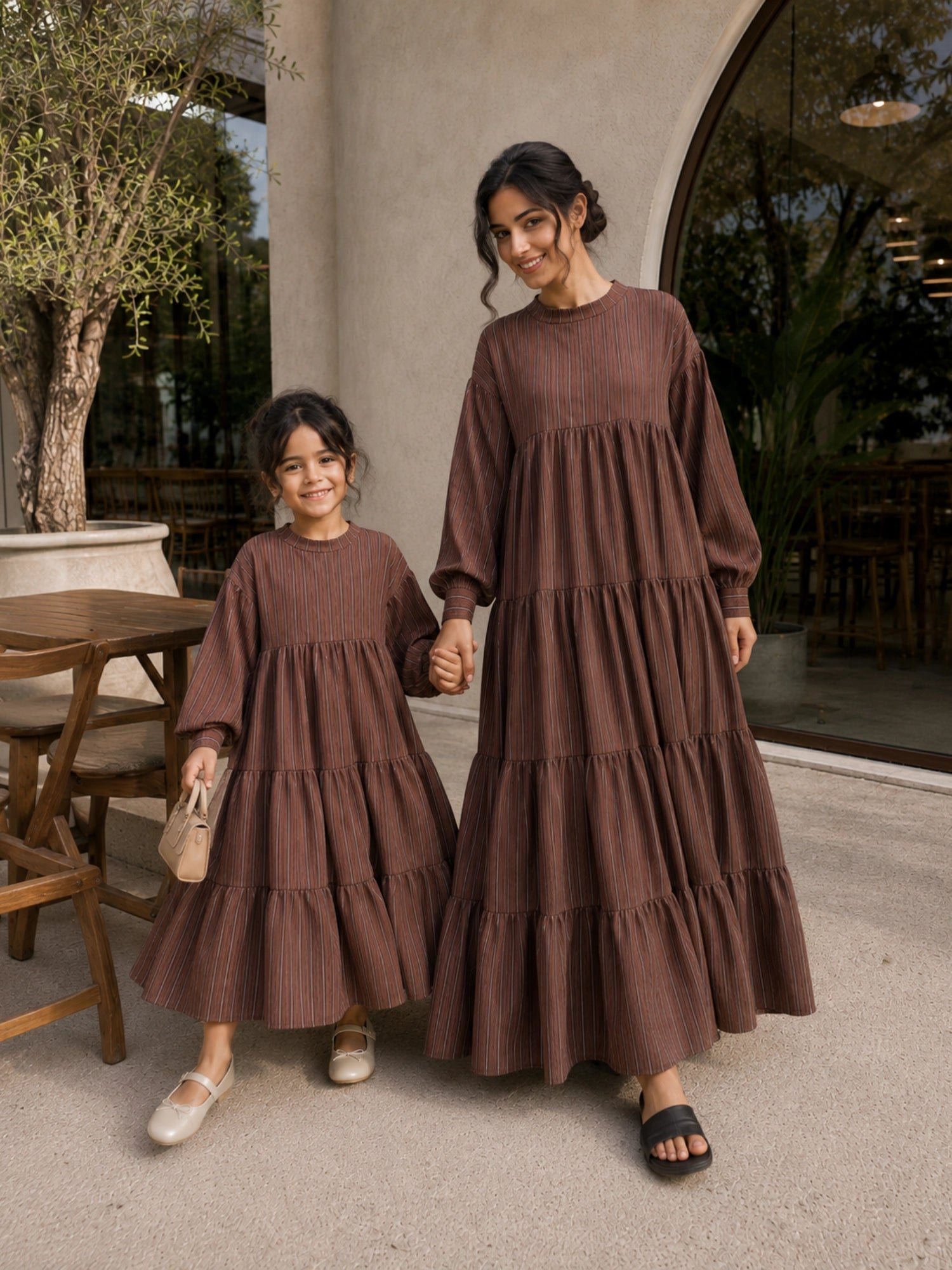 Mom and daughter matching tiered maxi dress set in brown with long sleeves and flowing design