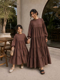 Mom and daughter matching tiered maxi dress set in brown with long sleeves and flowing design