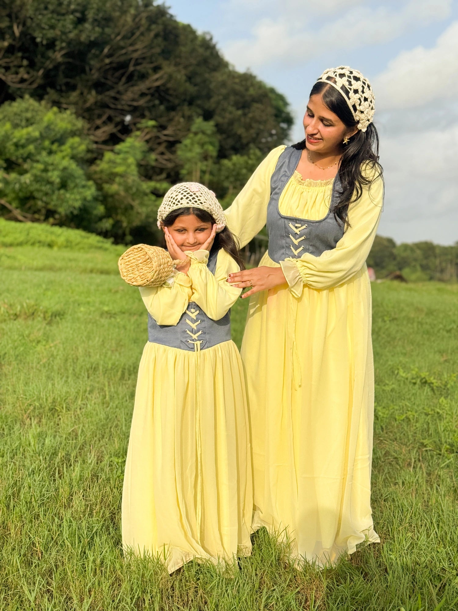 Mom & Daughter Matching Pastel Yellow Corset Maxi Dress Set with Denim Bodice in a grassy outdoor setting