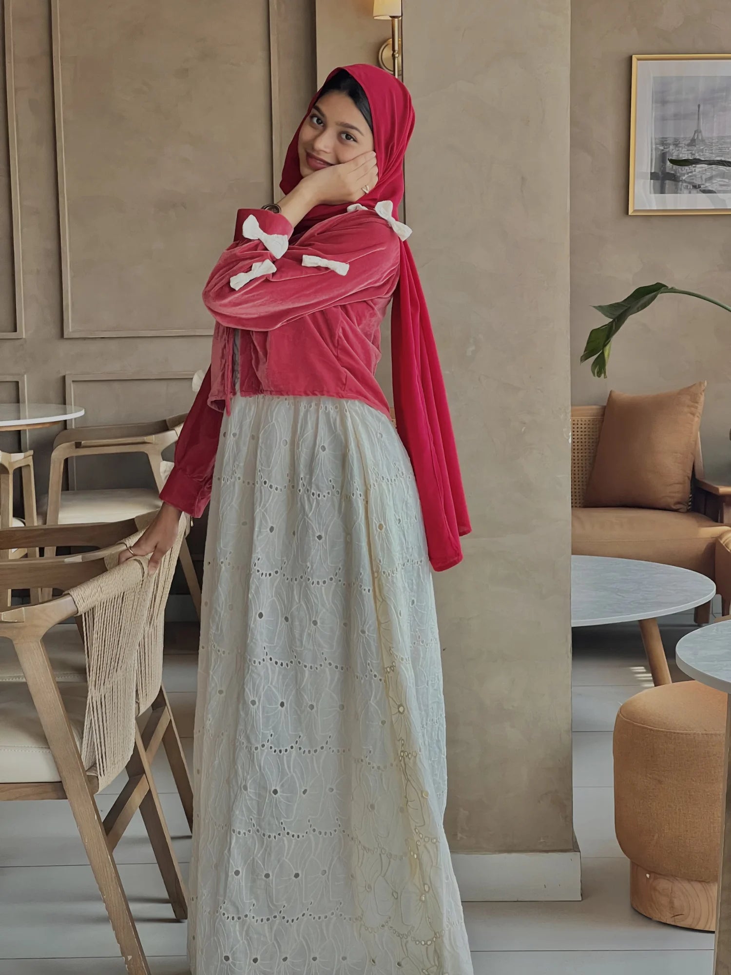 Side pose of Pinterest-inspired bow detail maxi dress for women in red and white, featuring bow accents, layered embroidered skirt, modest fit, and hijab styling
