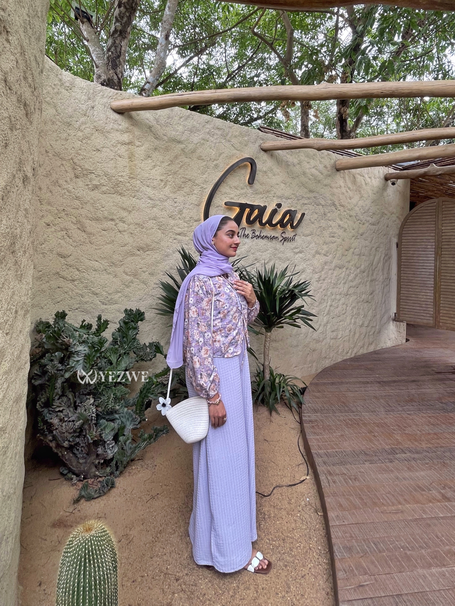 Modest lavender maxi dress by YEZWE with a floral shawl and stylish handbag against a natural backdrop
