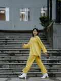 Stylish woman wearing a yellow oversized co-ord set while walking on outdoor stairs