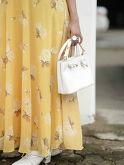 Yezwe yellow puff sleeve maxi dress with floral pattern, paired with a white handbag