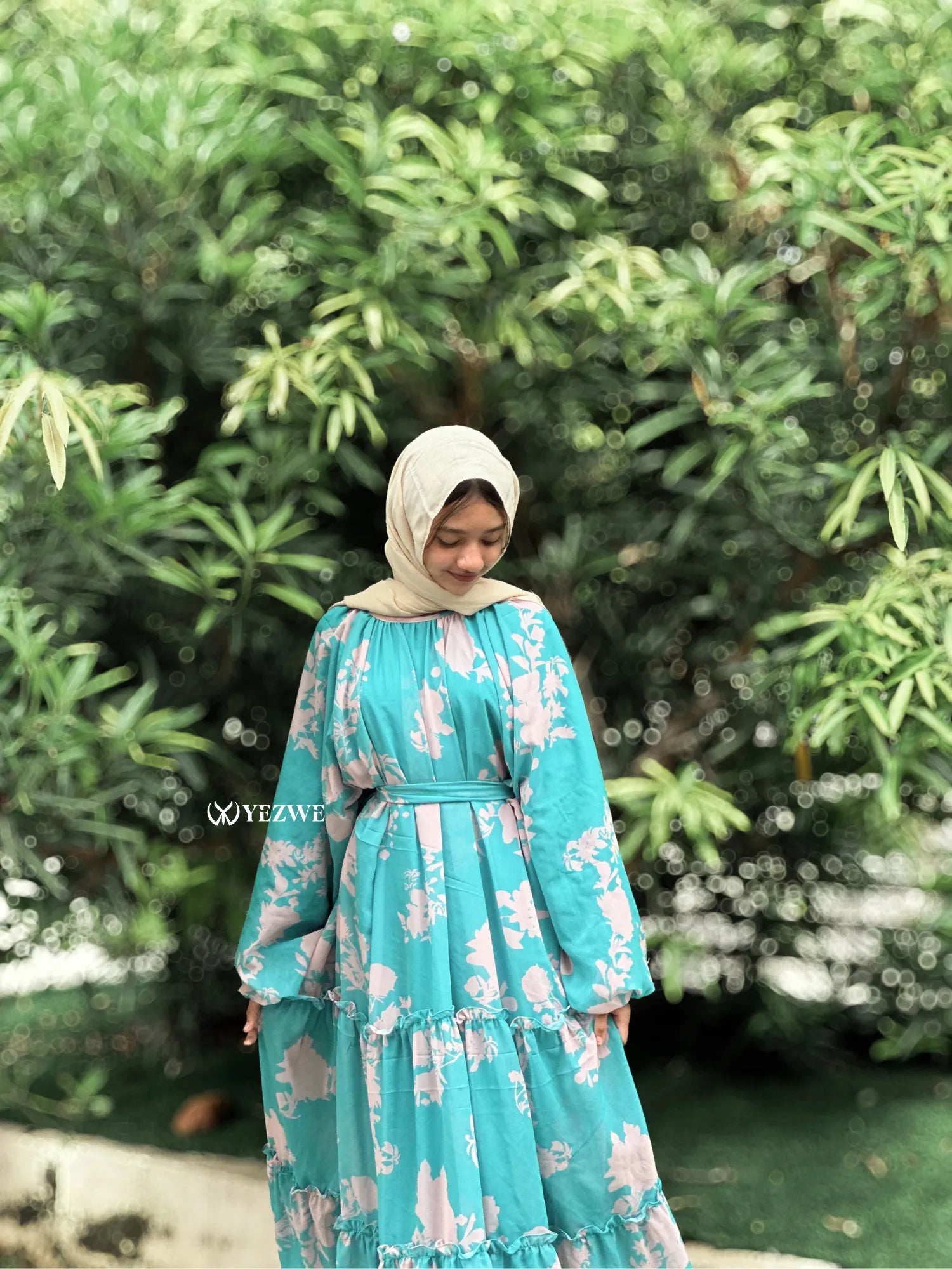 Aqua Blue Floral Maxi Dress by Yezwe, featuring elegant sleeves and a flowing silhouette among lush greenery.