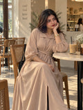 YEZWE Beige Pleated Cross-Waist Maxi Dress for Women worn by a model in a cafe setting