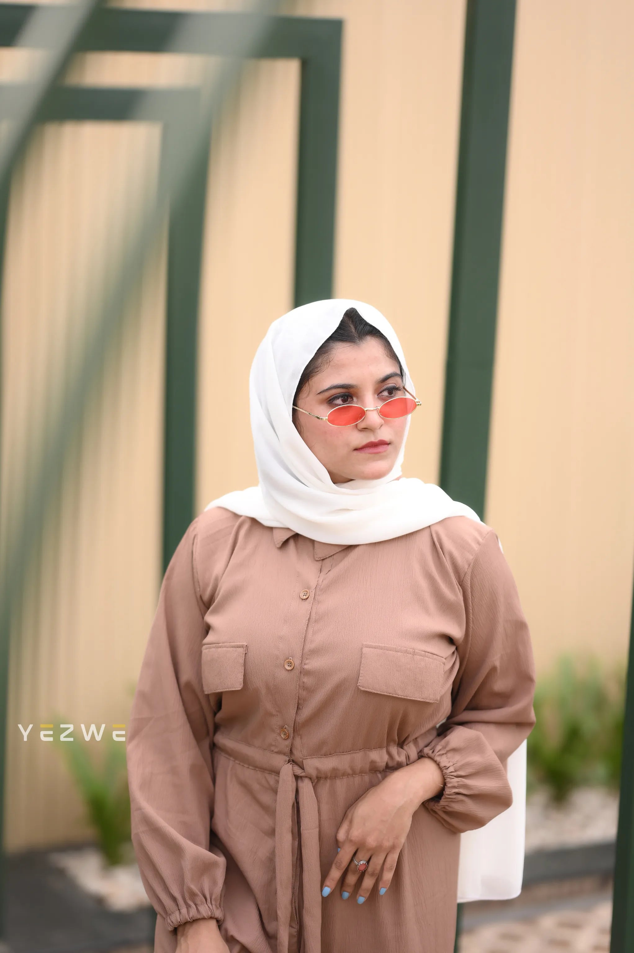 Yezwe belted front open jumpsuit in brown with long sleeves and stylish sunglasses