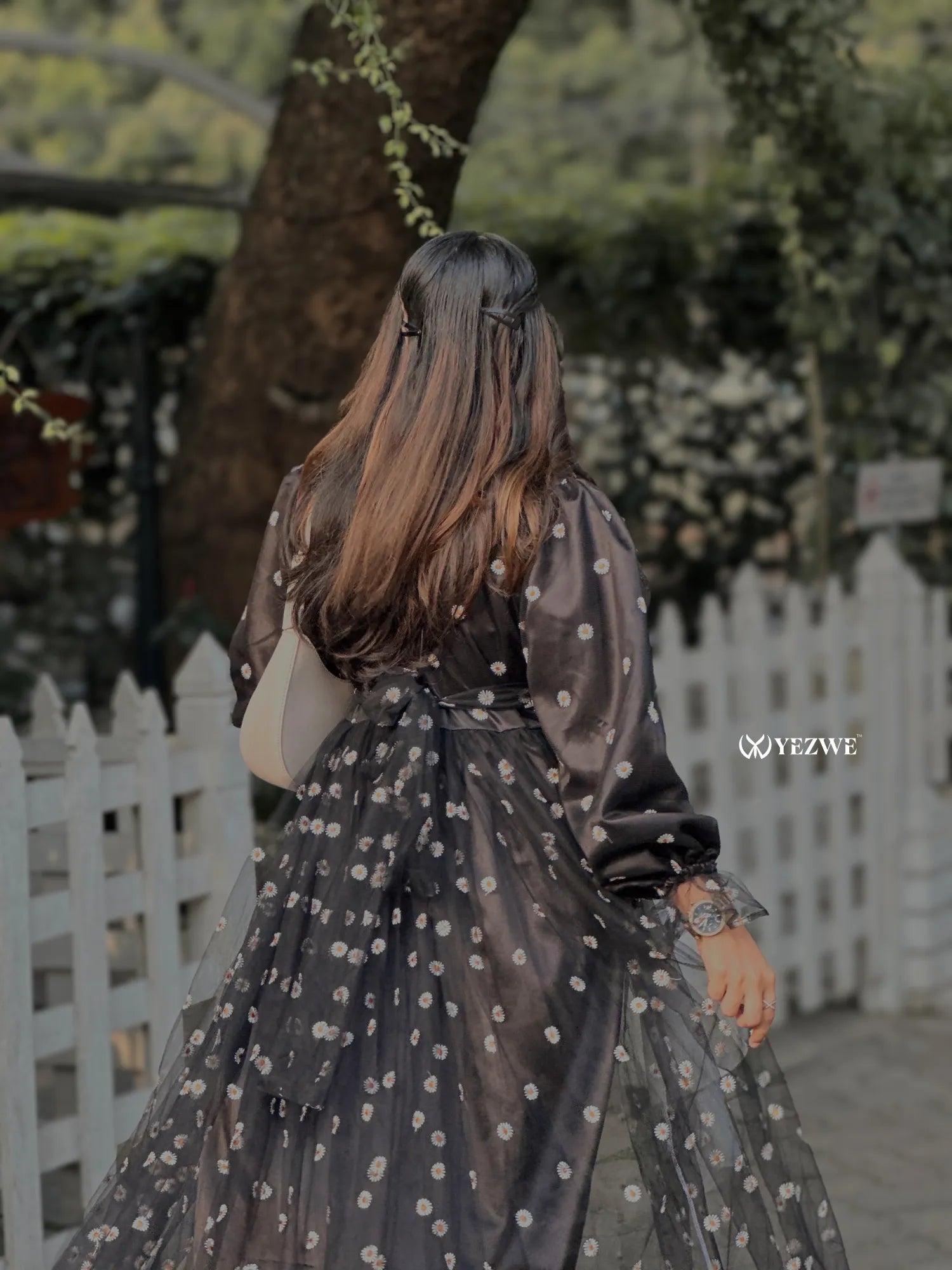 Back view of a Yezwe black floral embroidery gown with elegant sheer fabric and tied waist detail