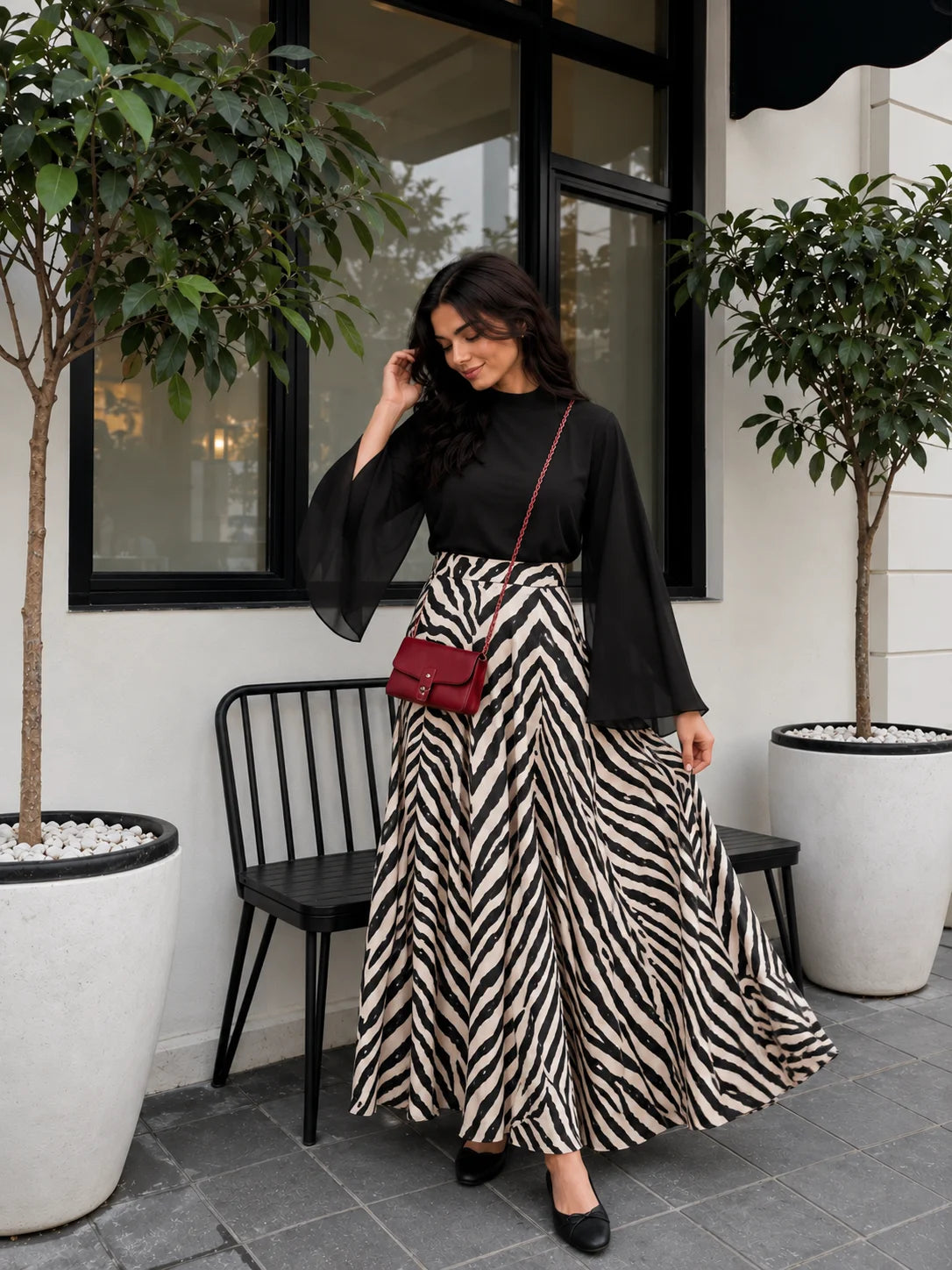 YEZWE Black Mock Neck Bell Sleeve Top & Zebra Print High Waist Flared Maxi Skirt styled with a red bag